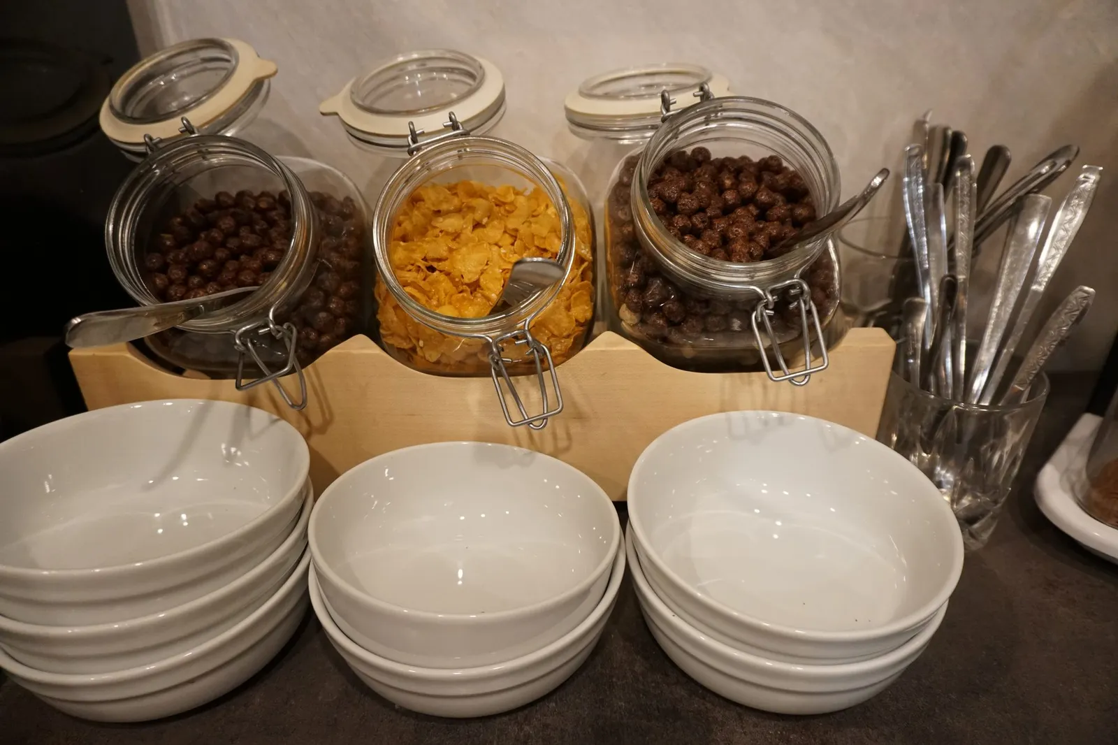 Cereal in glass jars, with bowls and cutlery
