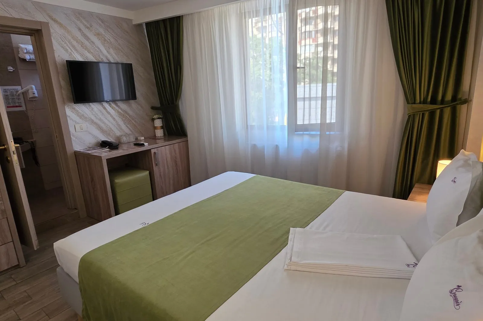 The green double room, seen from the headboard towards the window and desk