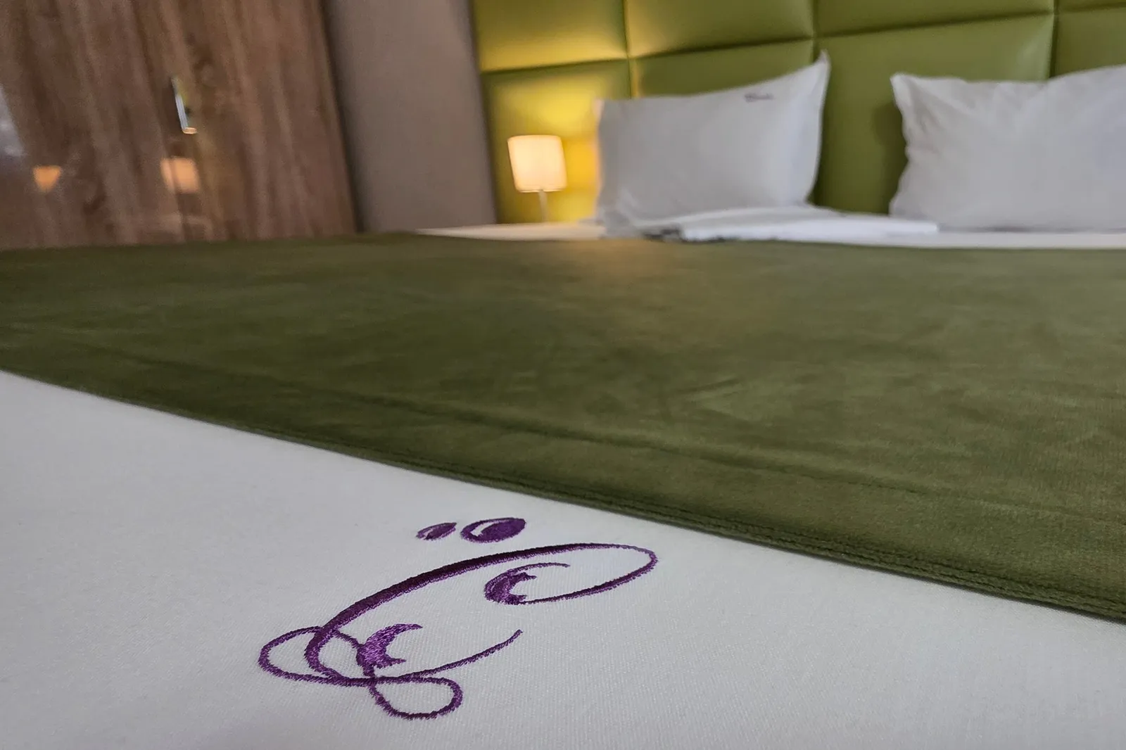 The “C” monogram embroidered on the double bed's bedspread