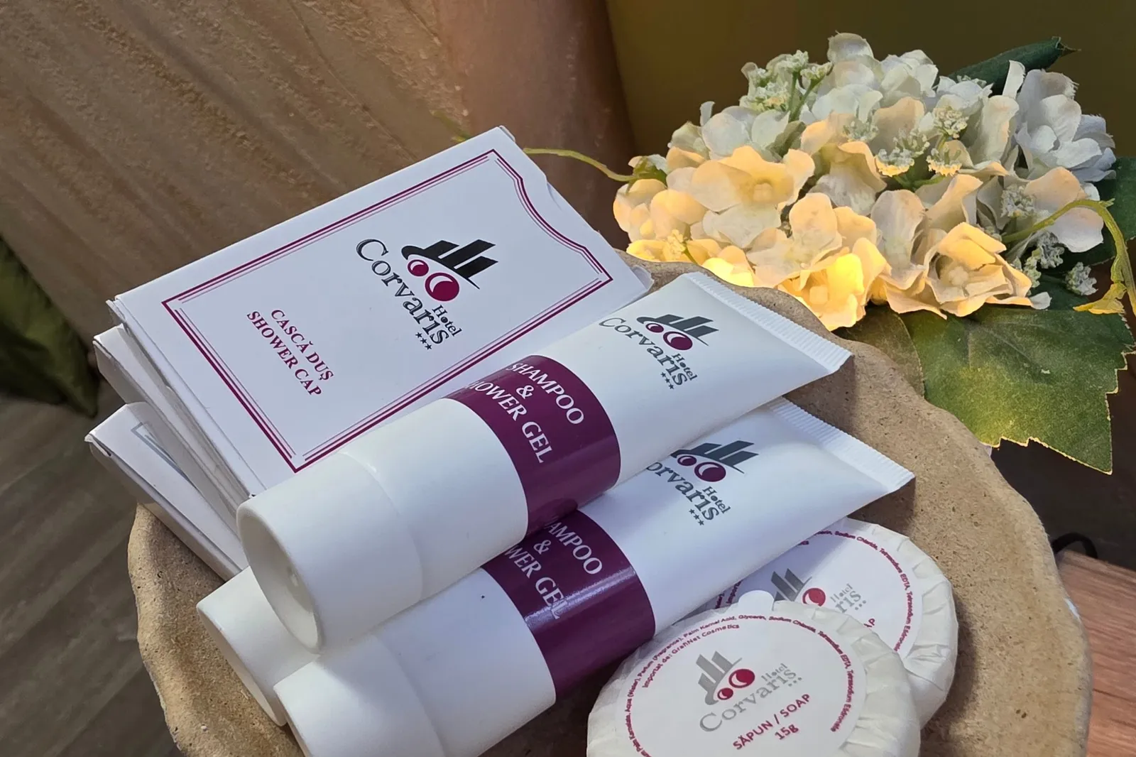 Corvaris toiletries on the bedside table, next to flowers
