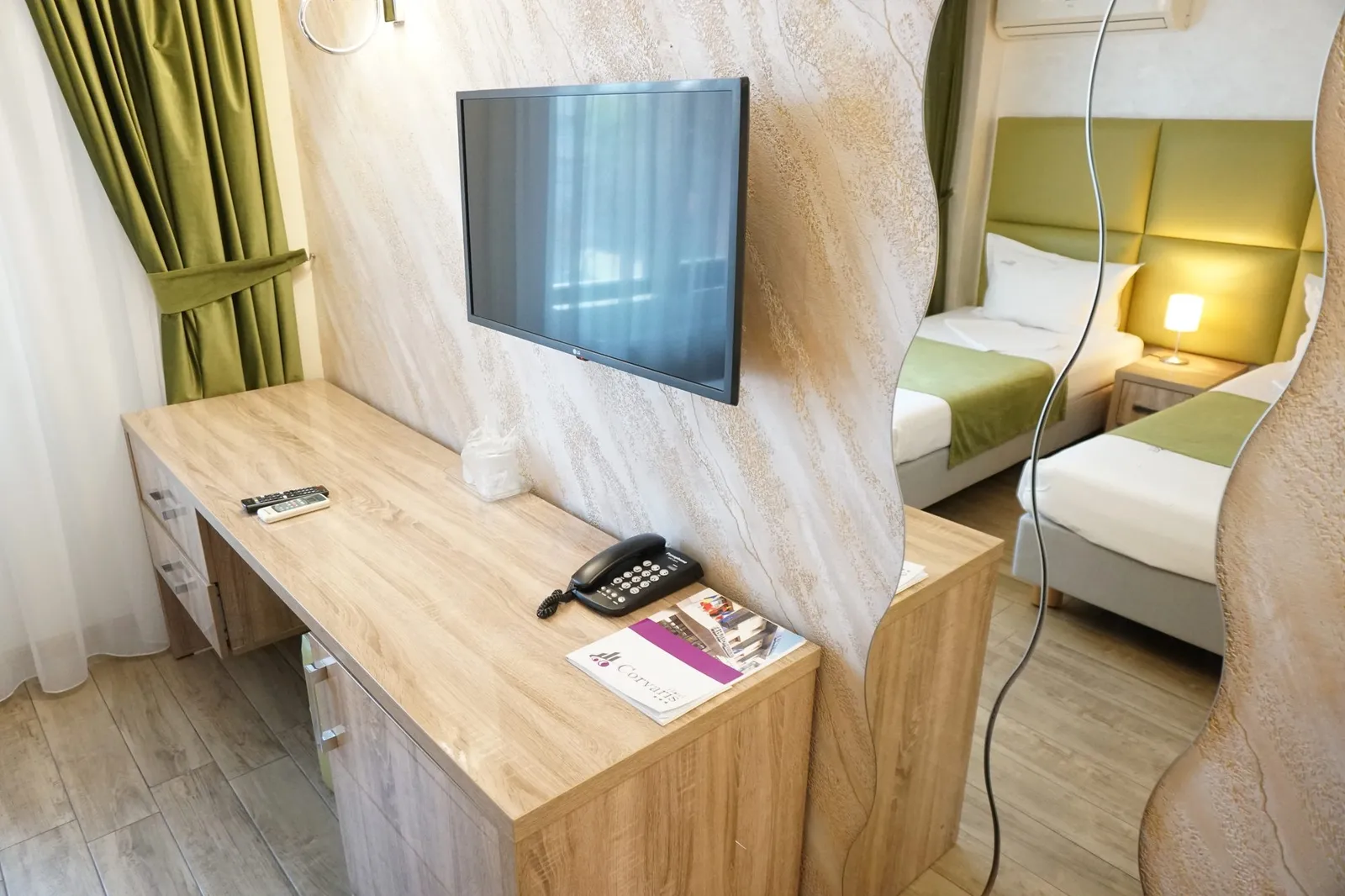 The desk, TV and wave mirror in the green twin room